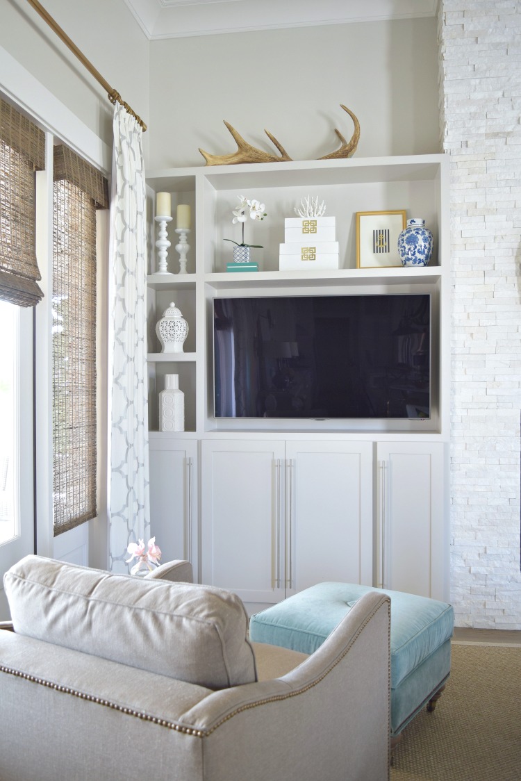 shelf styling accessories living room teal tufted ottoman white ginger jars gray cabinets