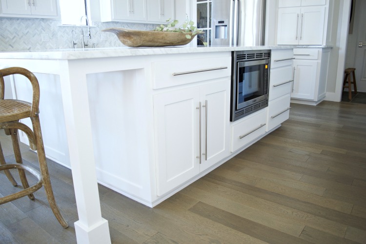 white kitchen island carrara marble counter tops herringbone backsplash modern shaker cabinets