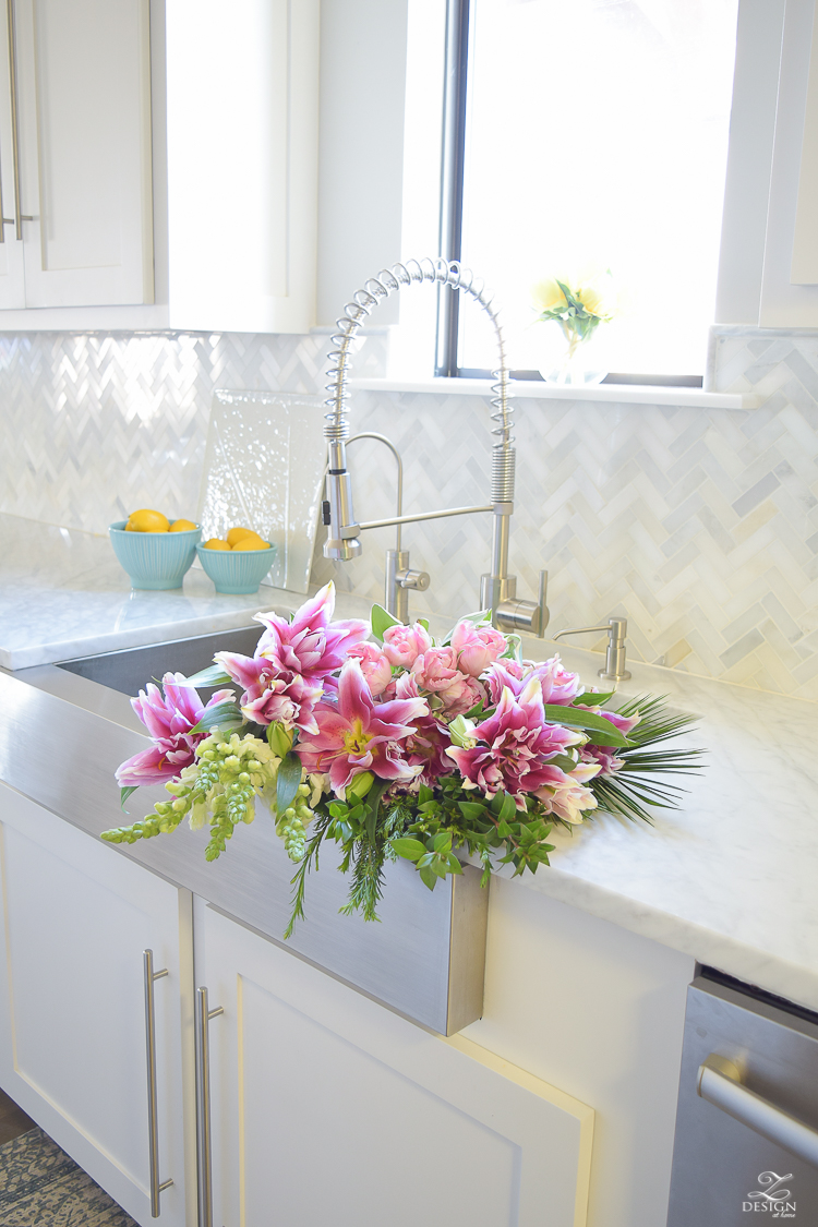 pink lillies white snap dragons flowers in the sink white kitchen