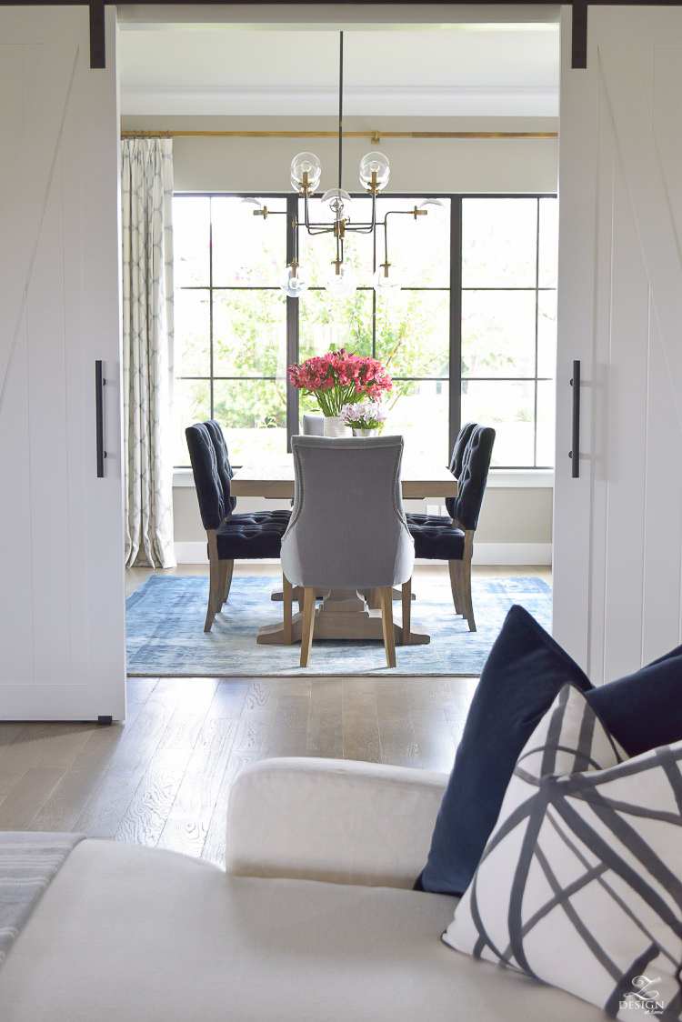 transitional dining room with rustic table and modern chandelier vintage inspired rug-2