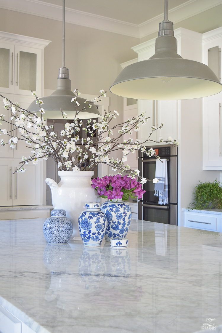 kitchen-island-styling-ideas-with-collection-of-vases-white-carrara-marble-farmhouse-pendants-chinoserie-blue-and-white-vases-3