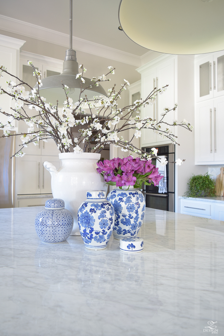 kitchen-island-styling-ideas-with-collection-of-vases-white-carrara-marble-farmhouse-pendants-chinoserie-blue-and-white-vases-4