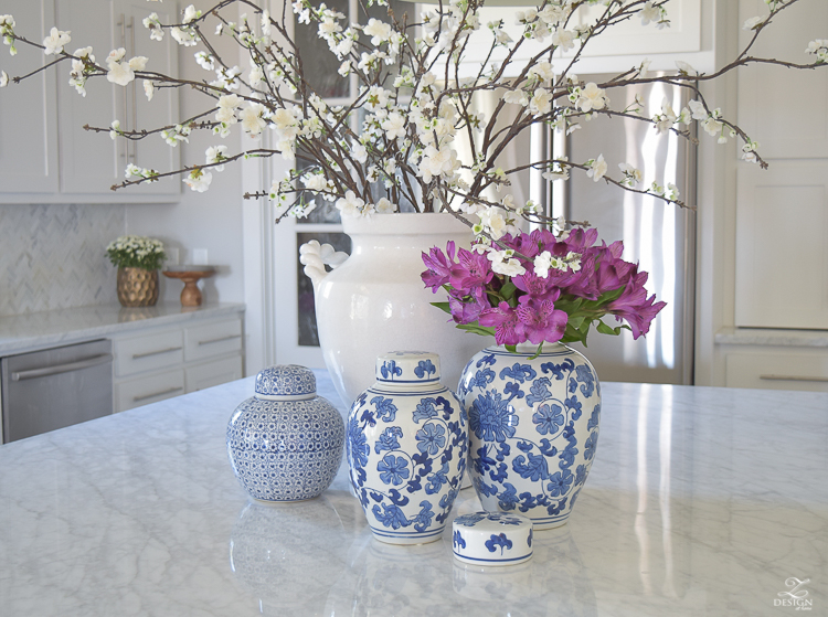 kitchen-island-styling-ideas-with-collection-of-vases-white-carrara-marble-farmhouse-pendants-chinoserie-blue-and-white-vases-6