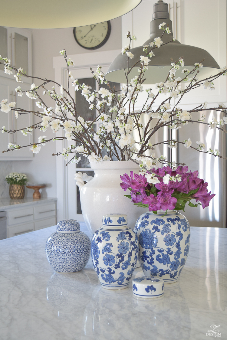 kitchen-island-styling-ideas-with-collection-of-vases-white-carrara-marble-farmhouse-pendants-chinoserie-blue-and-white-vases-7