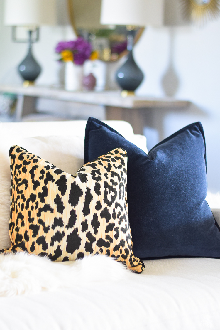 white-transitional-fall-living-room-chiang-mia-dragon-fabric-pillow-leaopard-pillows-fur-stools-kravet-riad-curtains-9