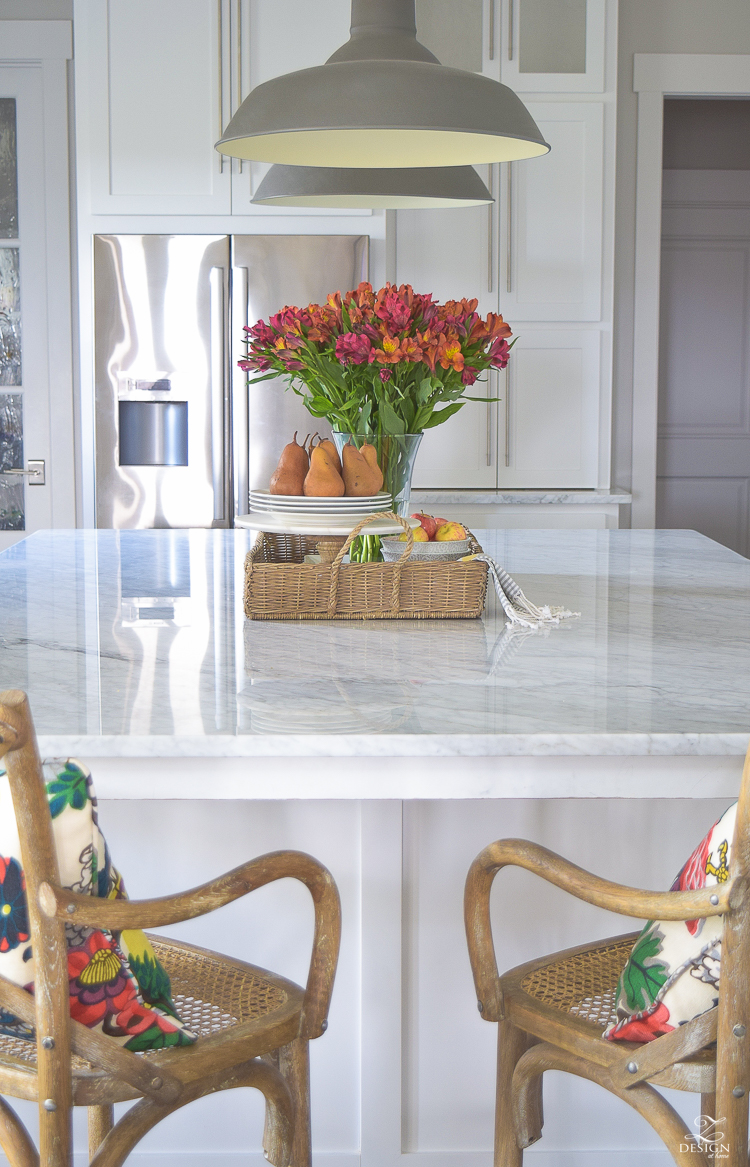 kitchen-island-styling-tips-with-baskets-fruit-and-flowers-carrara-marble-white-kitchen-herrinbone-backsplash-tile-3