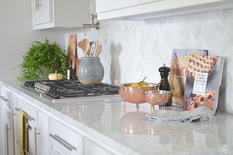 modern-fall-decor-in-the-kitchen-white-carrara-countertops-white-carrara-herringbone-backsplash-brass-pot-2