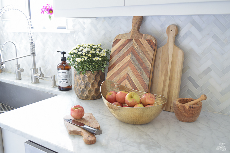 modern-fall-decor-in-the-kitchen-white-carrara-countertops-white-carrara-herringbone-backsplash-brass-pot-white-pumkins-5