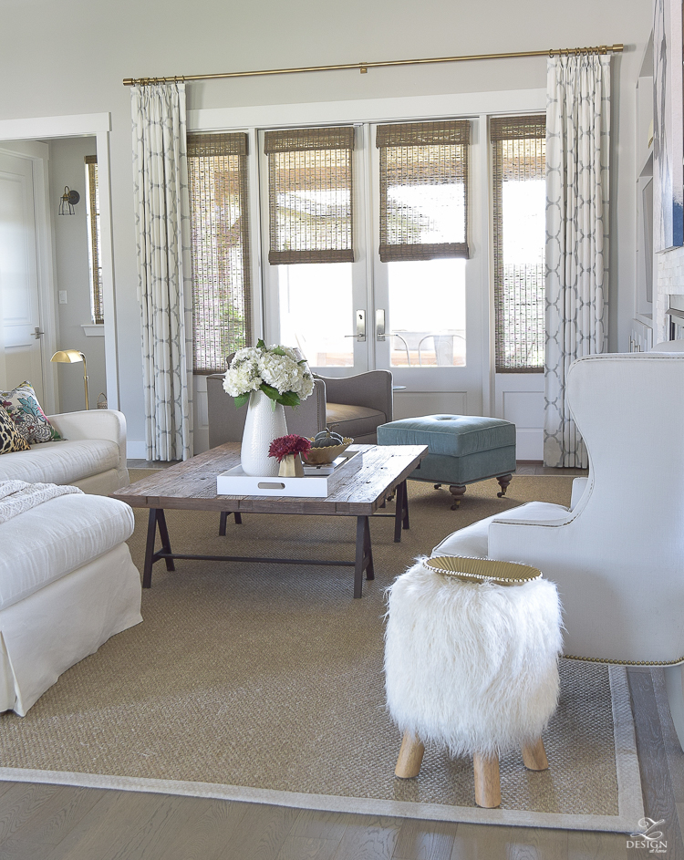 transitoinal-living-room-tour-restoration-hardware-couch-chaing-mia-dragon-fabric-seagrass-rug-navy-abstract-art-white-hydrangeas-fur-stools-7