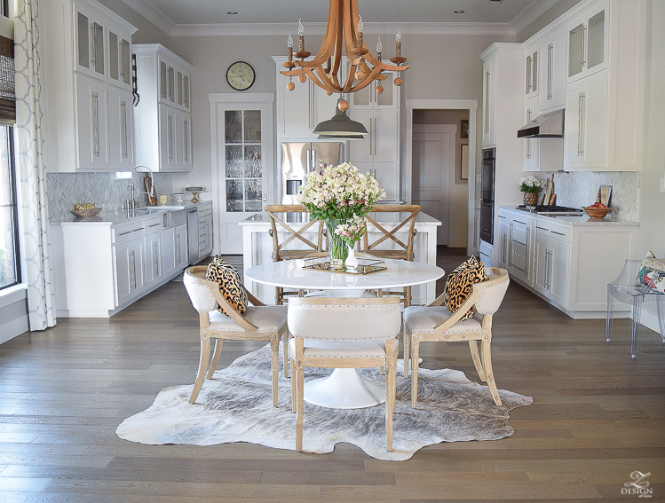 get-the-curl-out-of-cowhide-rug-white-farmhouse-kitchen-white-tulip-table-white-carrara-marble-marble-herringbone-tile-backsplash-4