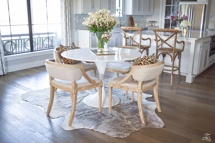 get-the-curl-out-of-cowhide-rug-white-farmhouse-kitchen-white-tulip-table-white-carrara-marble-marble-herringbone-tile-backsplash-4