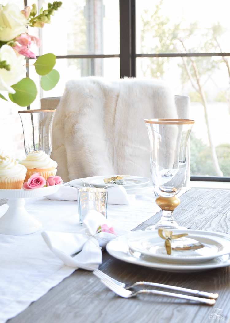 Valentines tablescape crystal heart ornament white fur throw flower arrangement with white roses pink snap dragons white cupcakes white dishes-3