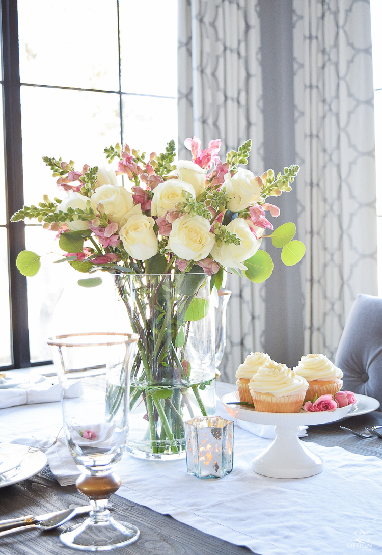 Valentines tablescape crystal heart ornament white fur throw flower arrangement with white roses pink snap dragons white cupcakes white dishes-5