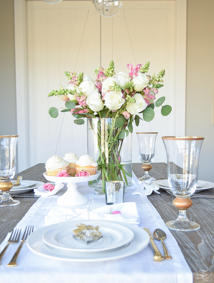 Valentines tablescape crystal heart ornament white fur throw flower arrangement with white roses pink snap dragons white cupcakes white dishes-7