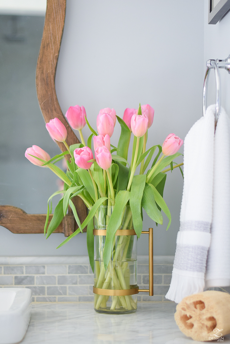 spring bathroom refresh brass and marble accessories wooden mirror white carrara marble brass and glass pitcher pink tulips marble backsplash-1