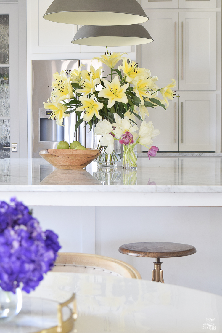 white-modern-farmhouse-kitchen-with-carrara-marble-counter-tops-white-shaker-cabinets-gray-farmhouse-pendants-white-tulip-table-swivel-barstools-with-brass-legs-1.jpg