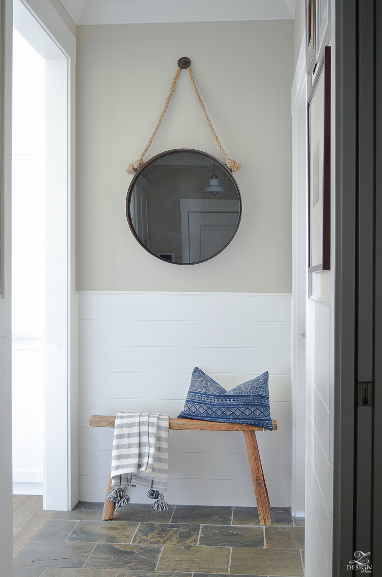 Hall way design rustic bench with tassel throw and hmong pillow round black mirror slate flooring white tounge and groove walls-2