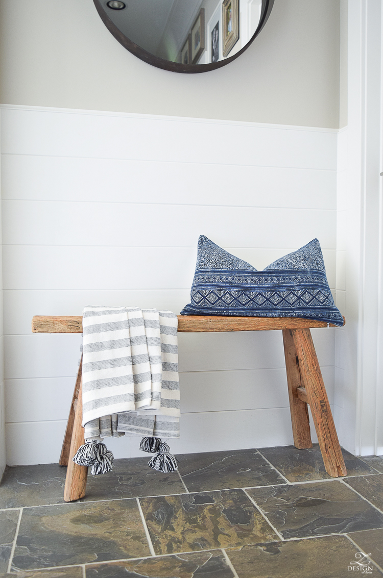 Hall way design rustic bench with tassel throw and hmong pillow round black mirror slate flooring white tounge and groove walls-3