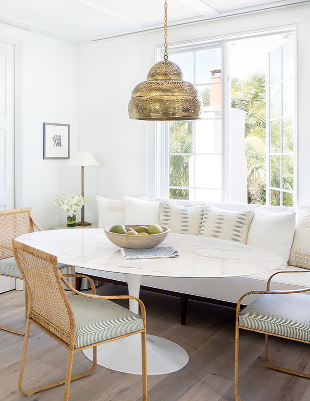 transitional dining space oval tulip table brass perforated chandelier