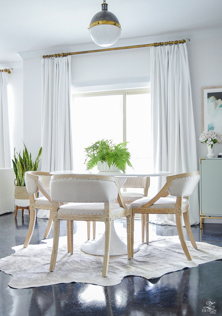 tulip table on cow hide rug white linen drapes with brass rod black concrete floors hicks pendant mid mod dining space geometric modern white flower pot-2