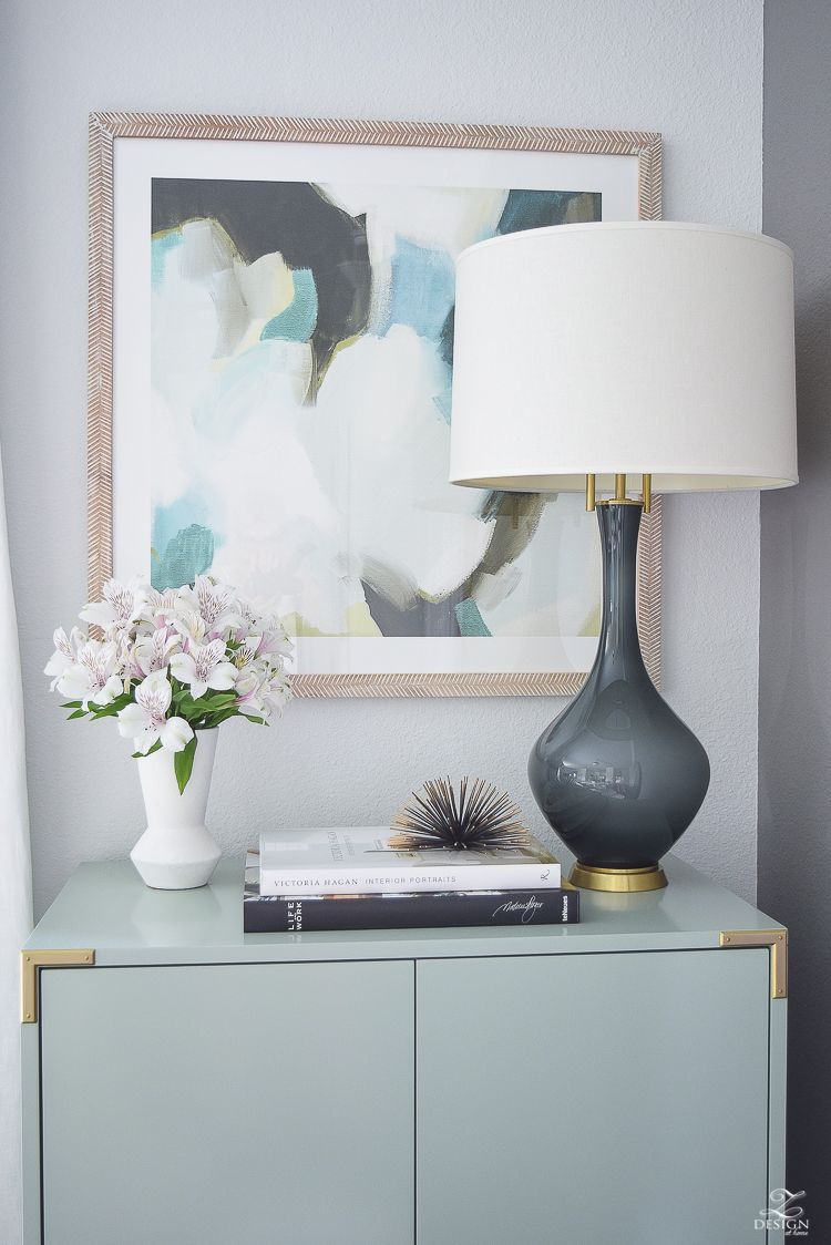 white linen drapes brass rod with crystal ball minted art gray lamp with brass base teal bar cabinet with brass accents black concrete floors console table styling-7