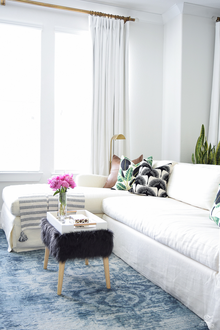 zdesign at home summer home tour blue vintage inspired rug white slip covered couch white walls white linen drapes black fur stool black and white pillows leather pillow-1