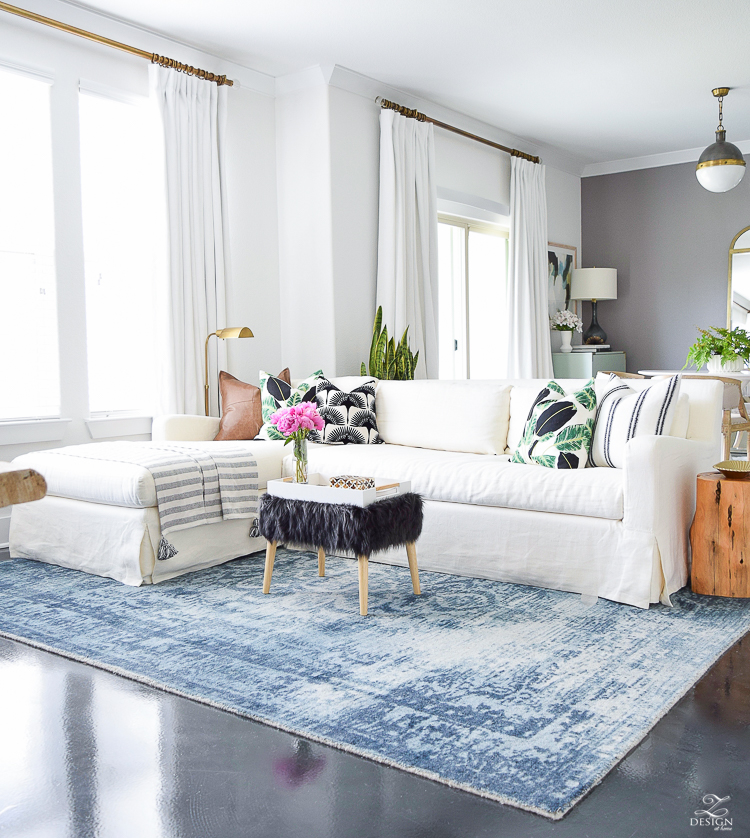 zdesign at home summer home tour blue vintage inspired rug white slip covered couch white walls white linen drapes black fur stool black and white pillows leather pillow-6