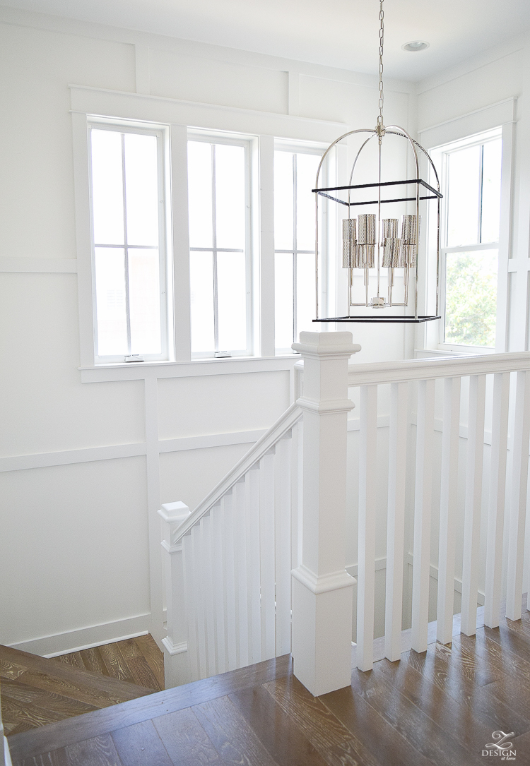 grid wall pattern in staircase with white walls blonde distressed hardwood floors chrome coastal chandelier beach house design coastal house decor how to design a beach house-1