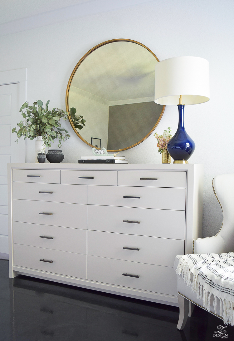 Transitional style master bedroom round gold mirror navy lamp with brass base dresser styling bedroom dresser decor modern gray dresser-4