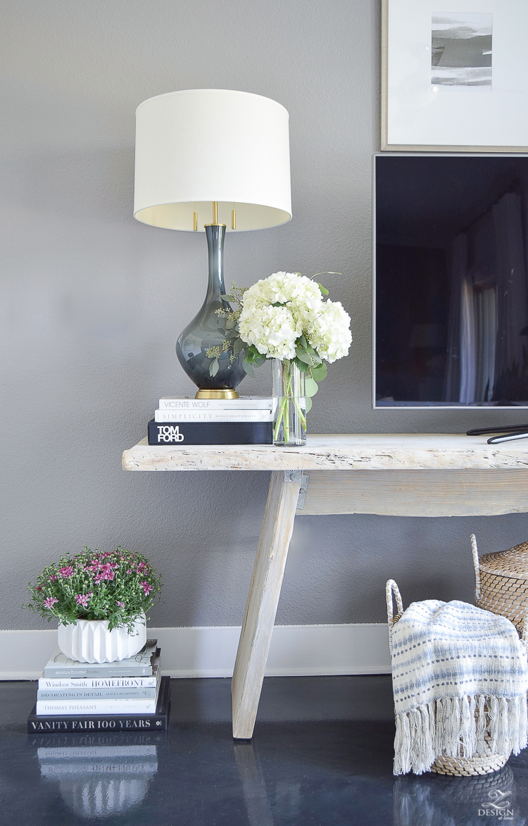 Fall Home Tour Decorating with books gray and brass table lamp distressed modern console table black concrete floors books stacked on floor with plant on top white fluted pot-2