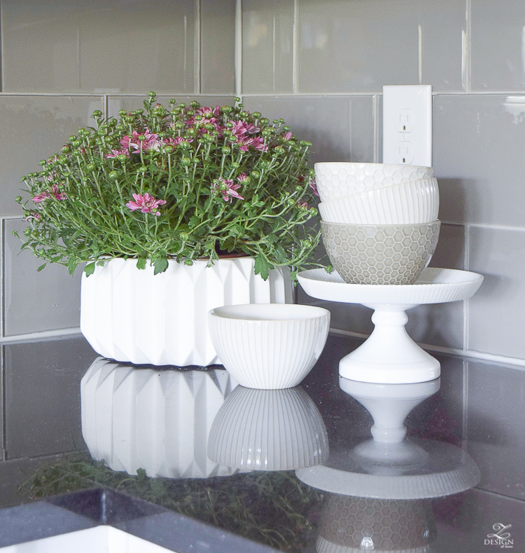 plum mums in a fluted pot white and gray geometric dishes