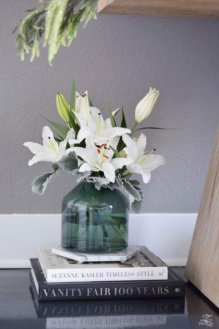 Christmas flowers in a green glass vase on marble trivet