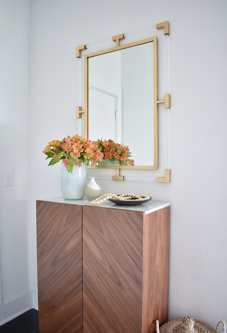 Small Transitional Entry That Packs A Big Punch - marble top shallow entry way cabinet and lucite gold mirror