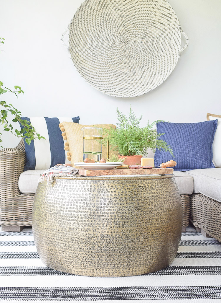 Sustainably source outdoor furniture and accessories - pom pom pillows, cheese board, hammered gold coffee table