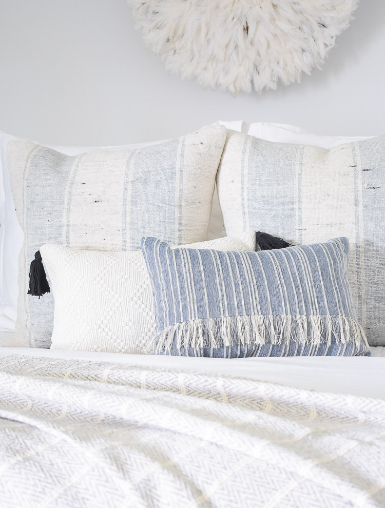 4 Subtle Ways To Add Coastal Decor To Your Home - Coastal Inspired Bedroom - white pillow with black tassels