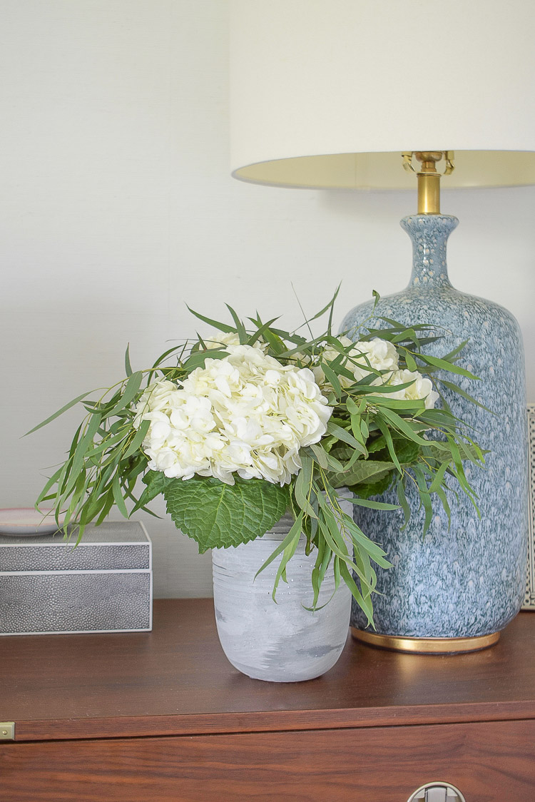 white hydrangeas, eucalyptus in cement vase 