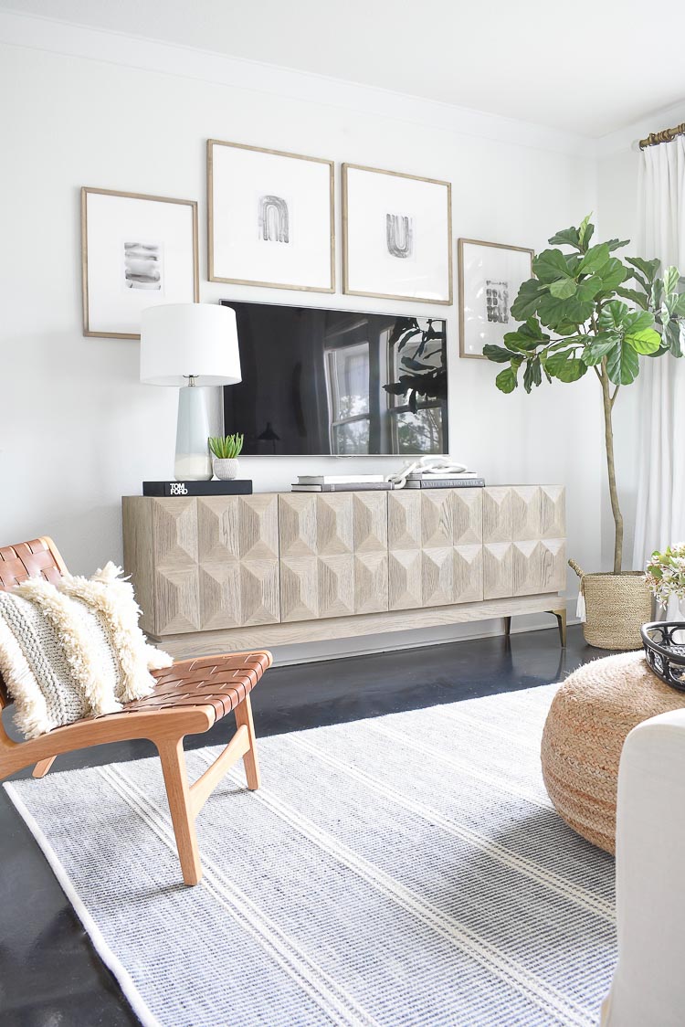 Modern TV gallery wall with faceted media cabinet and frames styled around TV