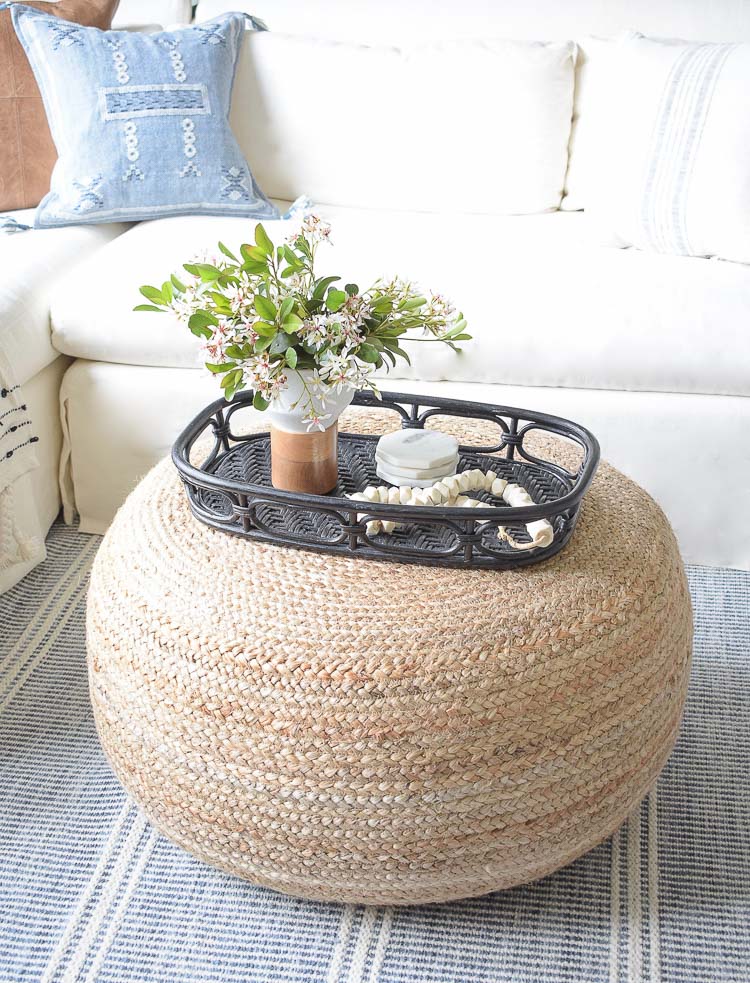 Spring flower arrangement on coffee table / jute round ottoman 