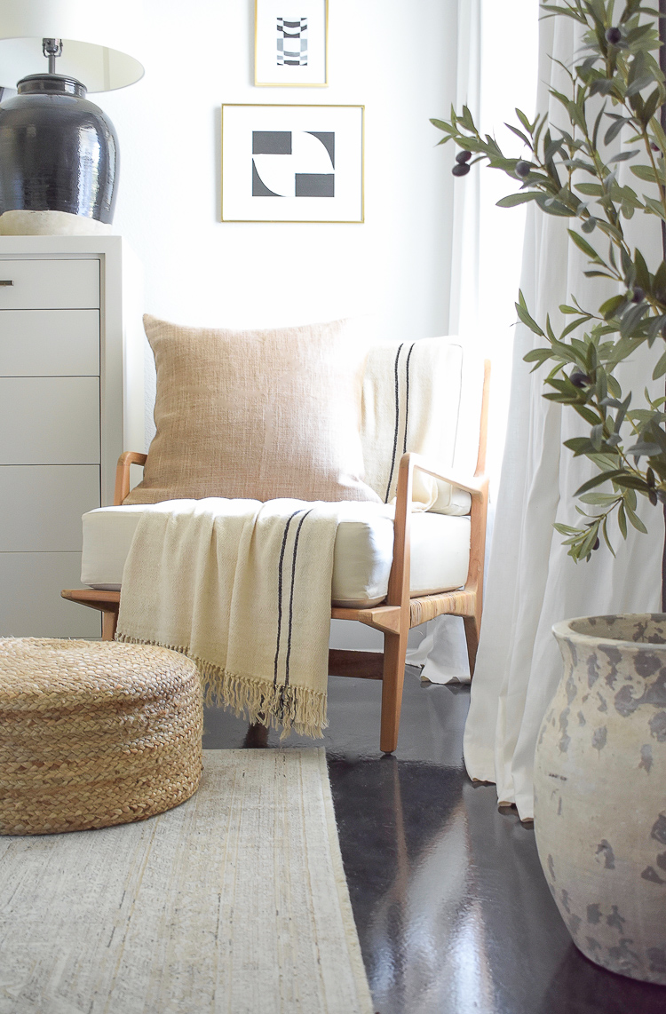 Boho chic chair in this fall neutral layered bedroom