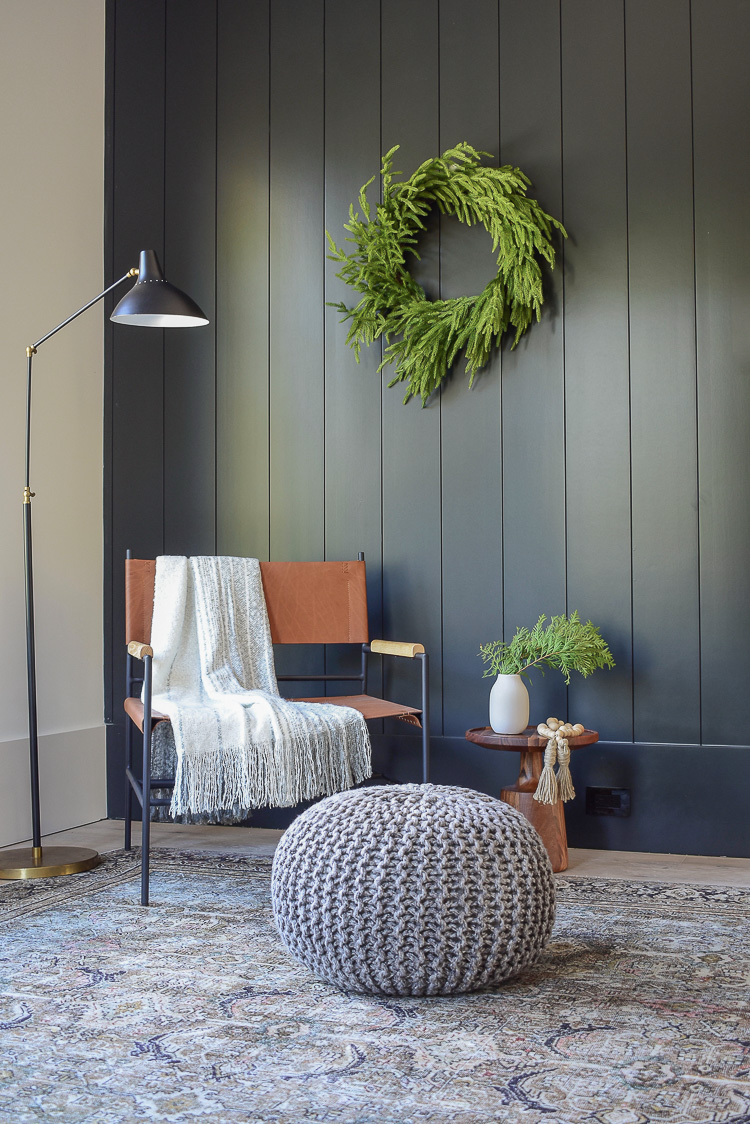 Modern leather chair, black vertical shiplap wall, olive charcoal loiloi rug from Joss & Main