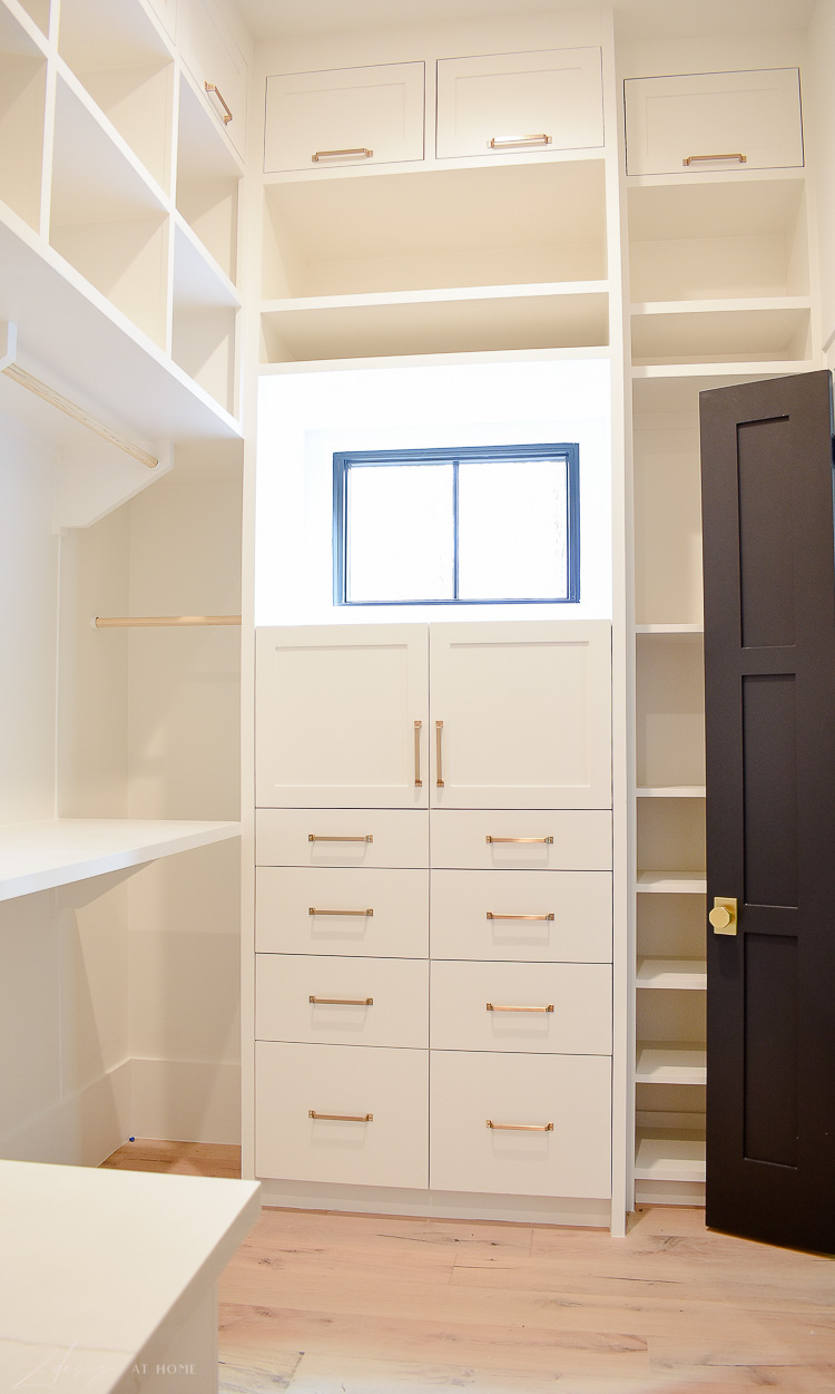 Closet design with white inset cabinets, brass hardware, white oak floors 