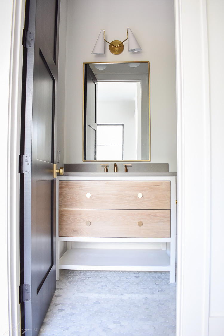 bathroom with two tone vanity white and white oak, gray countertops and brass accents 