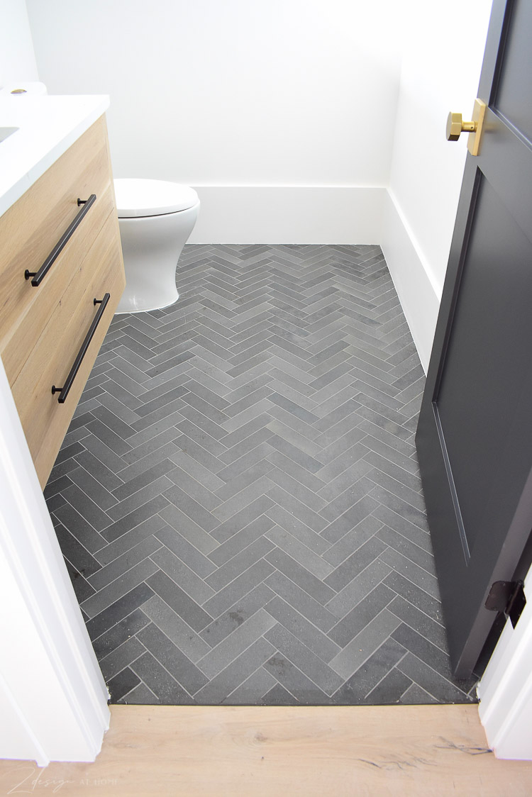 black, charcoal gray herringbone tile floors in powder bath