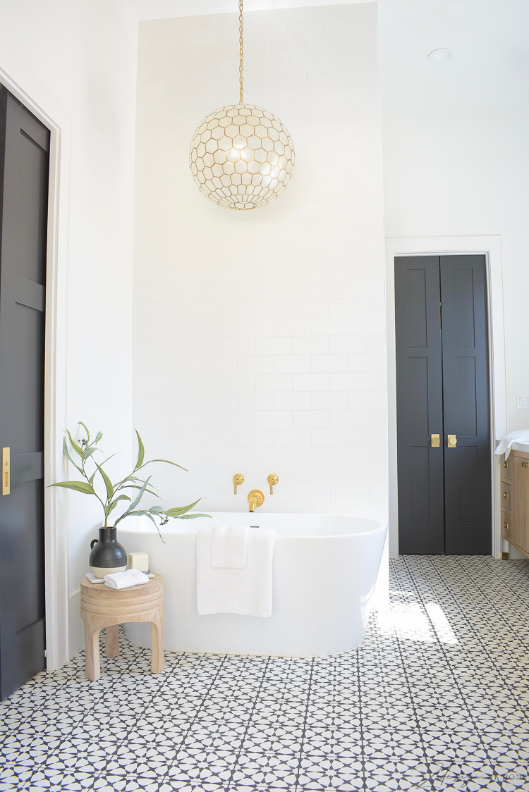 Joss & Main Spring Edit - wooden stool styled beside free standing tub in black and white modern elegant bathroom