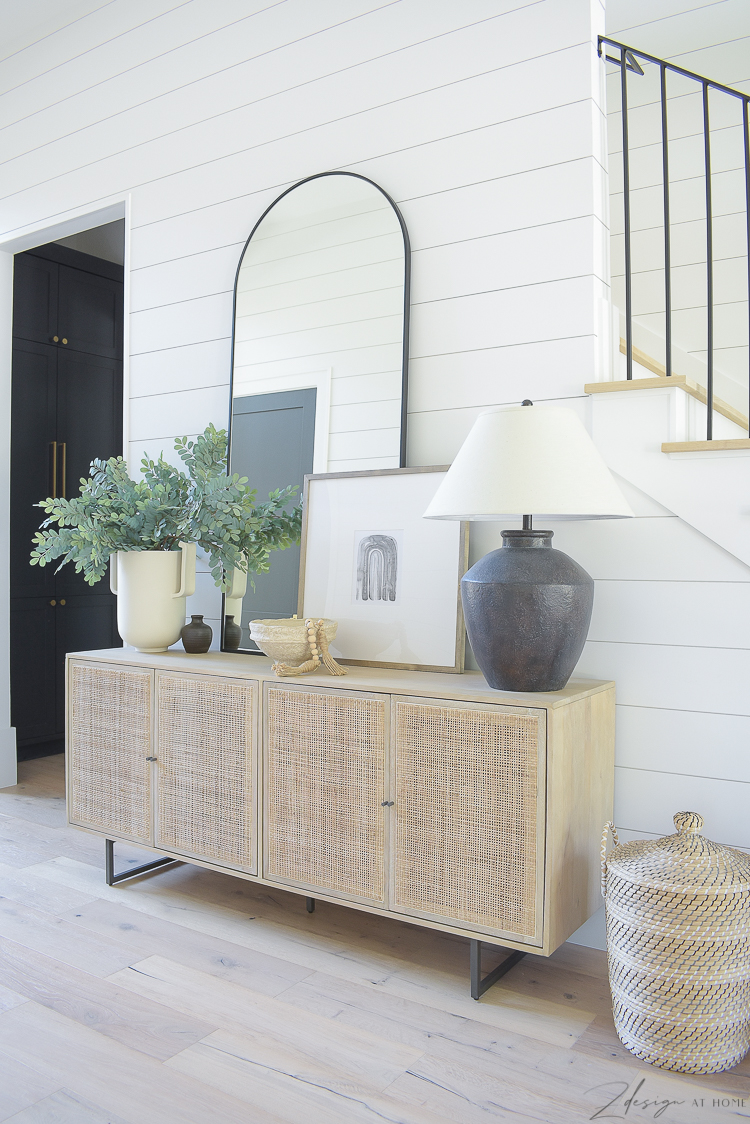 How to style a credenza with large arched black floor mirror, black lamp and large greenery