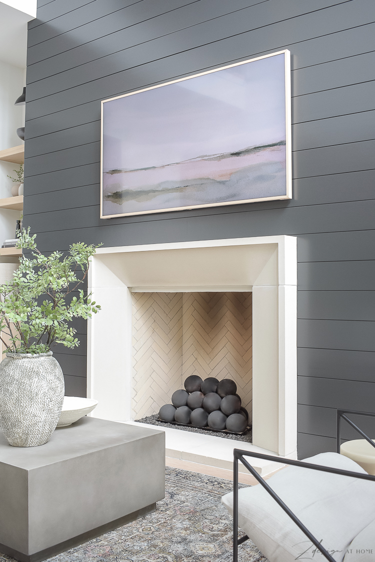 isokern fireplace with frame tv and black shiplap wall