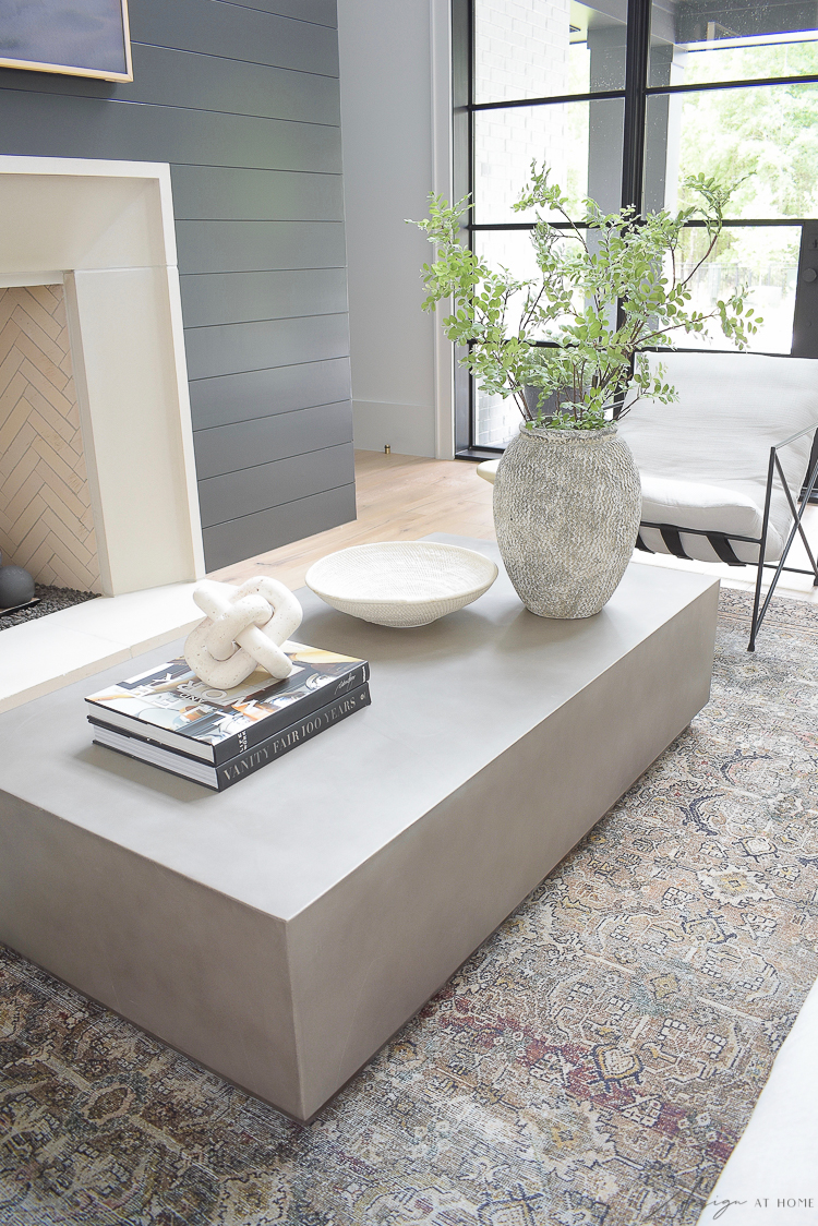 concrete coffee table with modern home decor accessories and black shiplap fireplace 