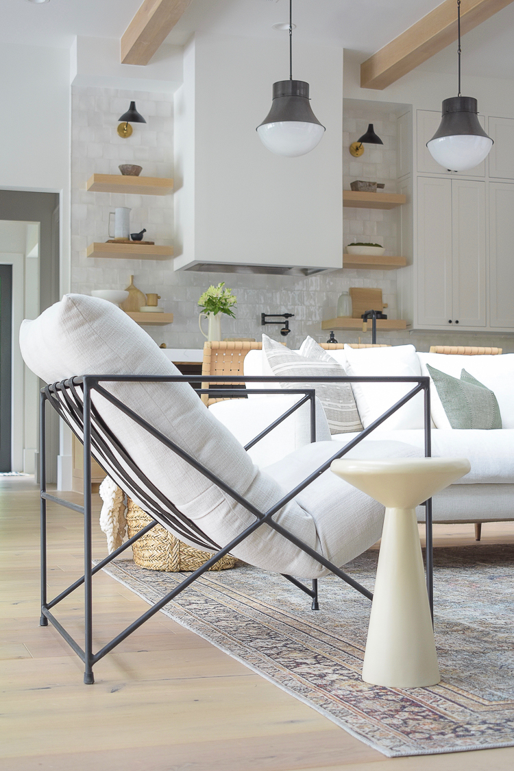 Concrete nesting tables next to modern metal side chair in transitional modern living room 