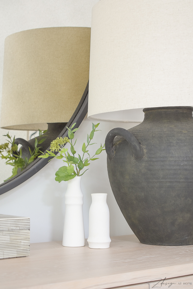 small white bud vases next to black boho lamp