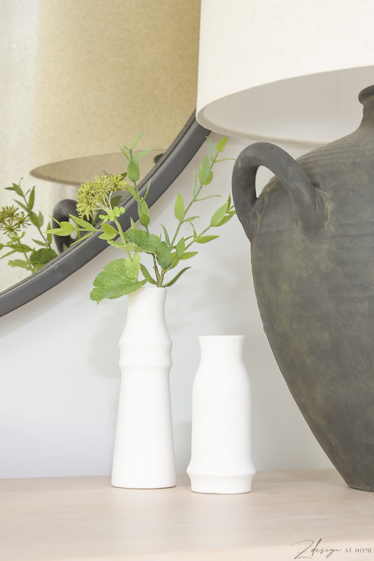 small white bud vases next to black boho lamp